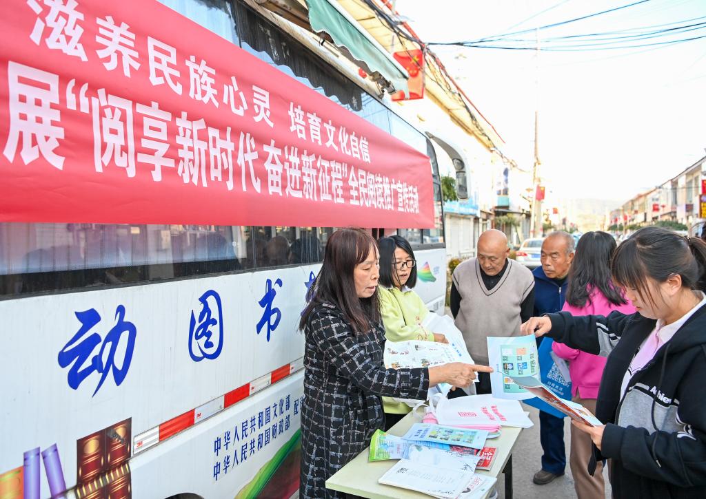 2023年10月24日，山西省左权县图书馆和左权县科学技术协会的工作人员在左权县寒王村向村民发放杂志和科普宣传单。新华社记者 杨晨光 摄